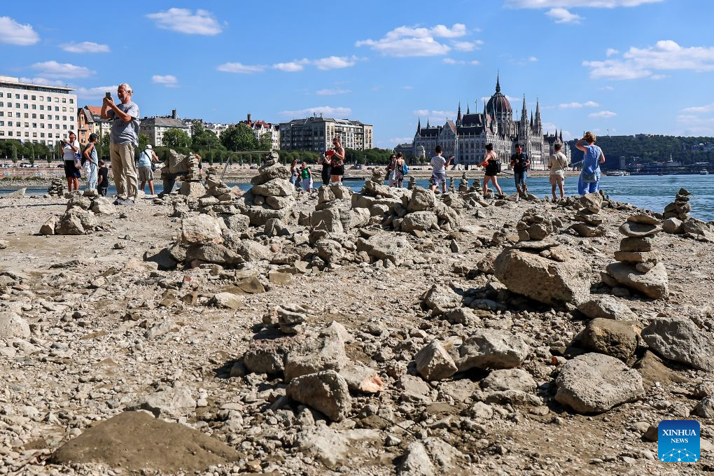 People explore the exposed riverbed of the Danube River in Budapest, Hungary, July 28, 2026. The water level of the Danube River in Budapest fell to a record low of 31 centimeters on Tuesday, according to Hungary's General Directorate of Water Management. The reading surpassed the previous record low of 33 centimeters which was measured on October 25, 2018, as prolonged drought and a lack of rainfall continue to affect much of the region. (Photo by David Balogh/Xinhua)