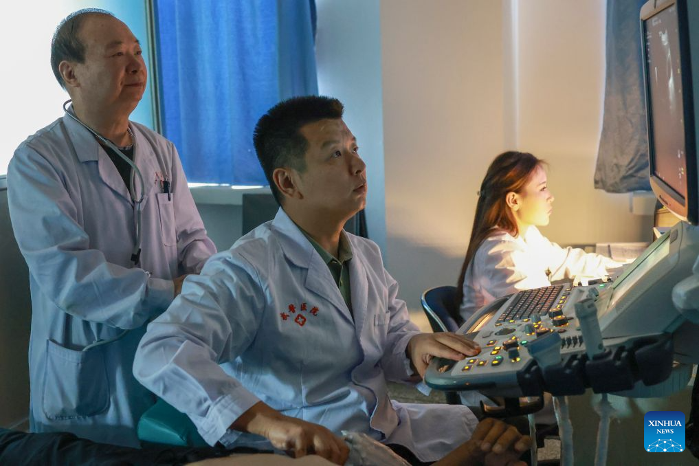 Zhuang Shihua (L) checks the ultrasound scan of a patient before a surgery at the hospital affiliated to the Xinjiang Armed Police Corps in Urumqi, northwest China's Xinjiang Uygur Autonomous Region, Aug. 18, 2026. (Xinhua/Wang Fei)