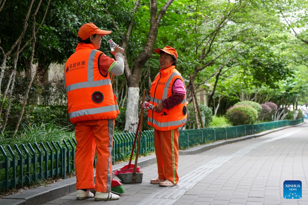 Sanitation workers in cooling vests are seen in Nanjing, east China's Jiangsu Province, July 28, 2026. Recently, in response to the high summer temperatures, sanitation workers in Xuanwu District of Nanjing City have been equipped with cooling vests. The vests are fitted with miniature fans on both sides of the waist, providing inward airflow. (Xinhua/Li Bo)