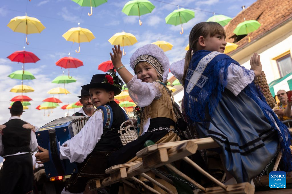 Children wearing Slovenian traditional costumes react during the parade of the 53rd National Costumes and Clothing Heritage Day in Kamnik, Slovenia, Sept. 13, 2026. The 53rd National Costumes and Clothing Heritage Day ended Sunday in Kamnik with a traditional parade, during which about 2,000 participants dressed in national costumes walked through the center of Kamnik. (Photo by Zeljko Stevanic/Xinhua)