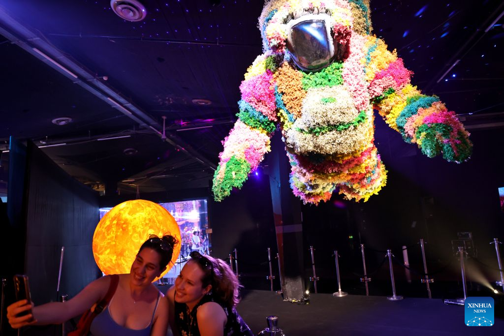 Visitors attend a flower exhibition in Tel Aviv, Israel, Aug. 18, 2026. Around 50 Israeli floral designers spent weeks using millions of flowers to create a vibrant floral wonderland. (Photo by Gil Cohen Magen/Xinhua)