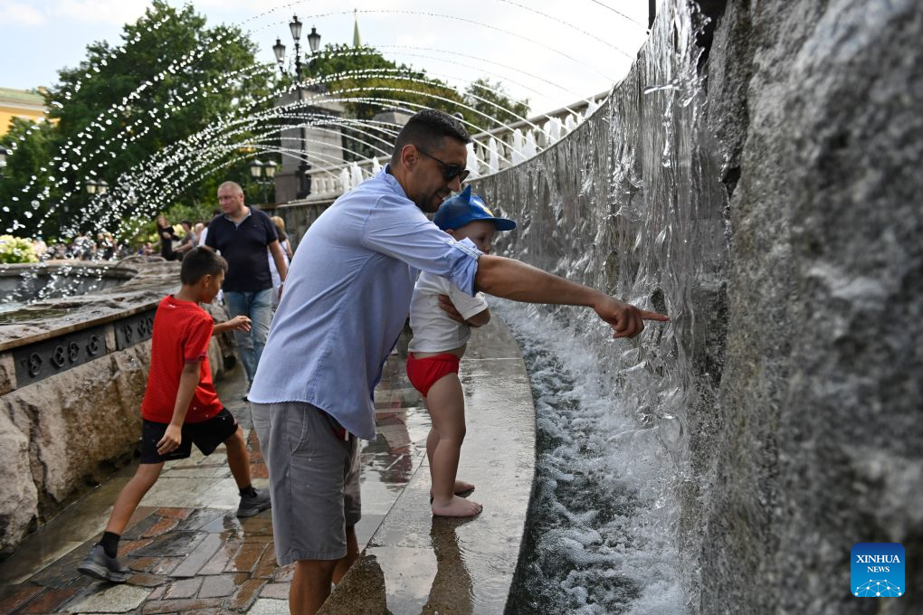 People cool off by a fountain near the Red Square amid a heatwave in Moscow, Russia, Aug. 6, 2026. (Photo by Alexander Zemlianichenko Jr/Xinhua)