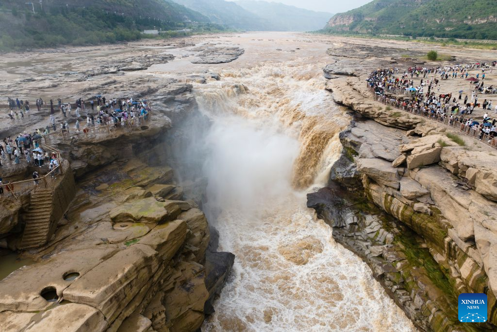 An aerial drone photo taken on Aug. 10, 2026 shows tourists visiting the Yellow River's Hukou Waterfall in northwest China's Shaanxi Province. (Xinhua/Shao Rui)