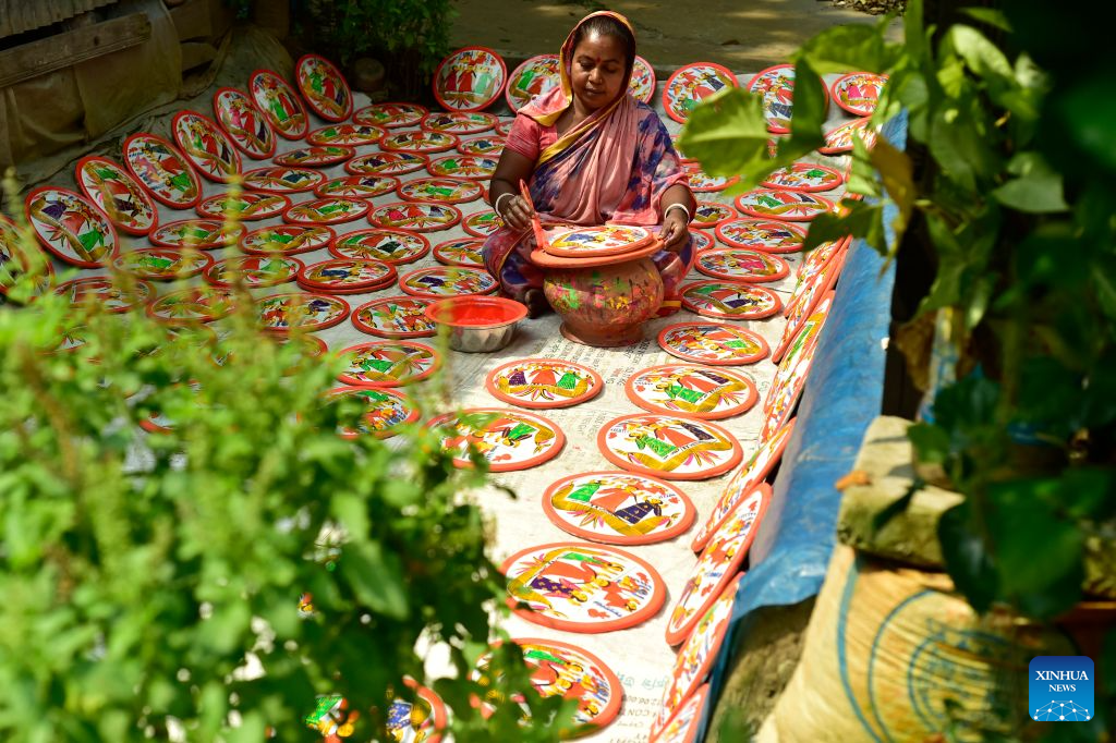 An artisan makes a traditional Lakshmi Sara in Munshiganj district, Bangladesh, Oct. 11, 2026. Lakshmi Sara is a round earthenware plate typically decorated with images of the Hindu goddess Lakshmi and other motifs and used in religious rituals. (Photo by Habibur Rahman/Xinhua)