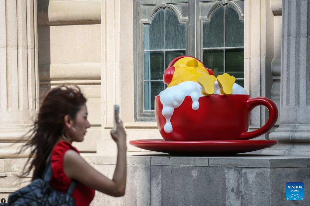 A tourist walks past an installation on Bajing Street, Shenyang City, northeast China's Liaoning Province, Aug. 1, 2026. A pack of coffee shops of varying styles on Bajing Street in Shenyang have breathed new life into the old city. Once quiet but obsolete, this historic street is now a vibrant new landmark of culture and tourism that attracts thousands of young visitors every day. Each coffee shop here tells a different story of how a city grows in time. (Xinhua/Pan Yulong)