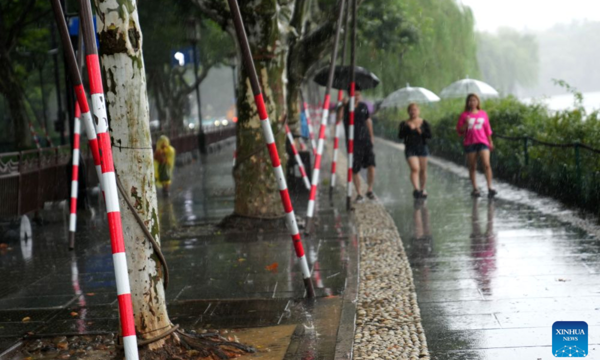 Visitors walk past temporarily reinforced trees along the West Lake in Hangzhou, east China's Zhejiang Province, Aug. 9, 2026. China's national observatory on Sunday activated a red alert -- the highest level in the country's typhoon warning system -- as Typhoon Dolphin approaches.

Typhoon Dolphin is forecast to make landfall along the country's east coast from Zhoushan in Zhejiang Province to Fuding in Fujian Province, according to the National Meteorological Center (NMC). (Xinhua/Han Chuanhao)