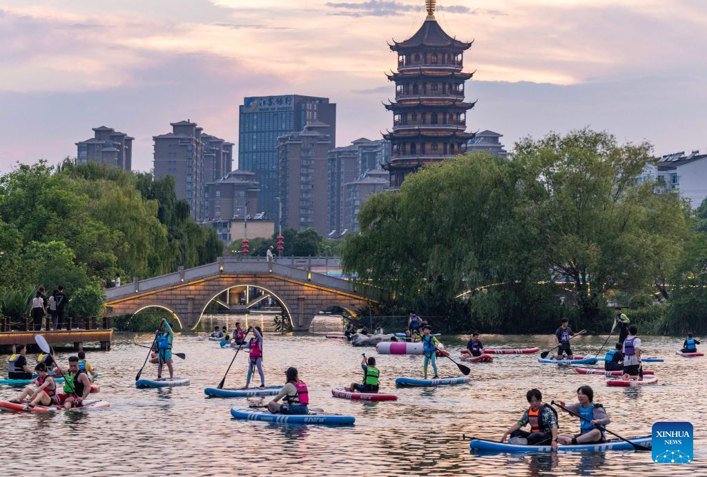 People play paddle boards at a scenic area in Hailing District, Taizhou City, east China's Jiangsu Province, Aug. 2, 2026. (Photo by Tang Dehong/Xinhua)
