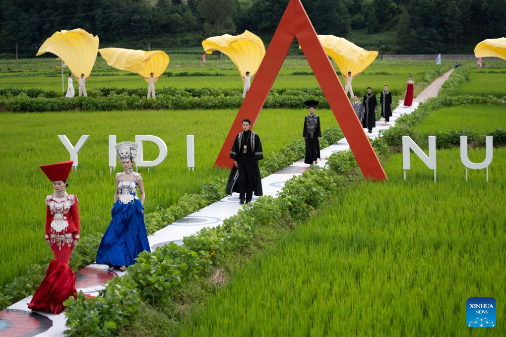 Models dressed in traditional ethnic costumes walk amid a rice field during a fashion show at Qietuo Village in Yuexi County of Liangshan Yi Autonomous Prefecture, southwest China's Sichuan Province, on Aug. 4, 2026. Sixty models from across the Liangshan Yi Autonomous Prefecture on Tuesday showcased traditional ethnic costumes and fashion creations here. (Xinhua/Jiang Hongjing)