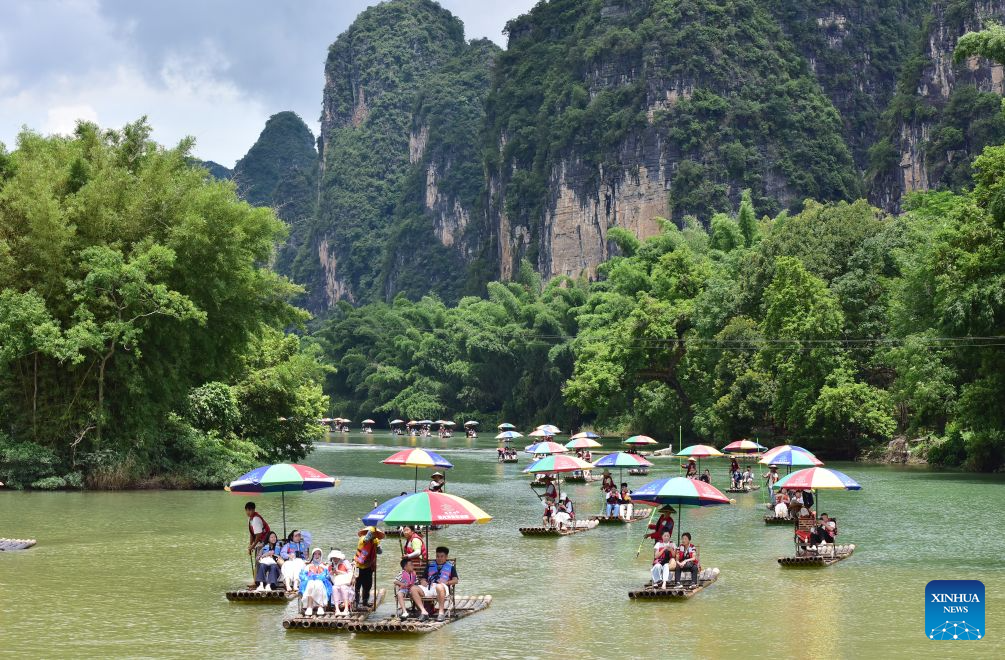People enjoy rafting on Yulong River in Yangshuo County, Guilin City, south China's Guangxi Zhuang Autonomous Region, Aug. 2, 2026. (Photo by Liao Zuping/Xinhua)
