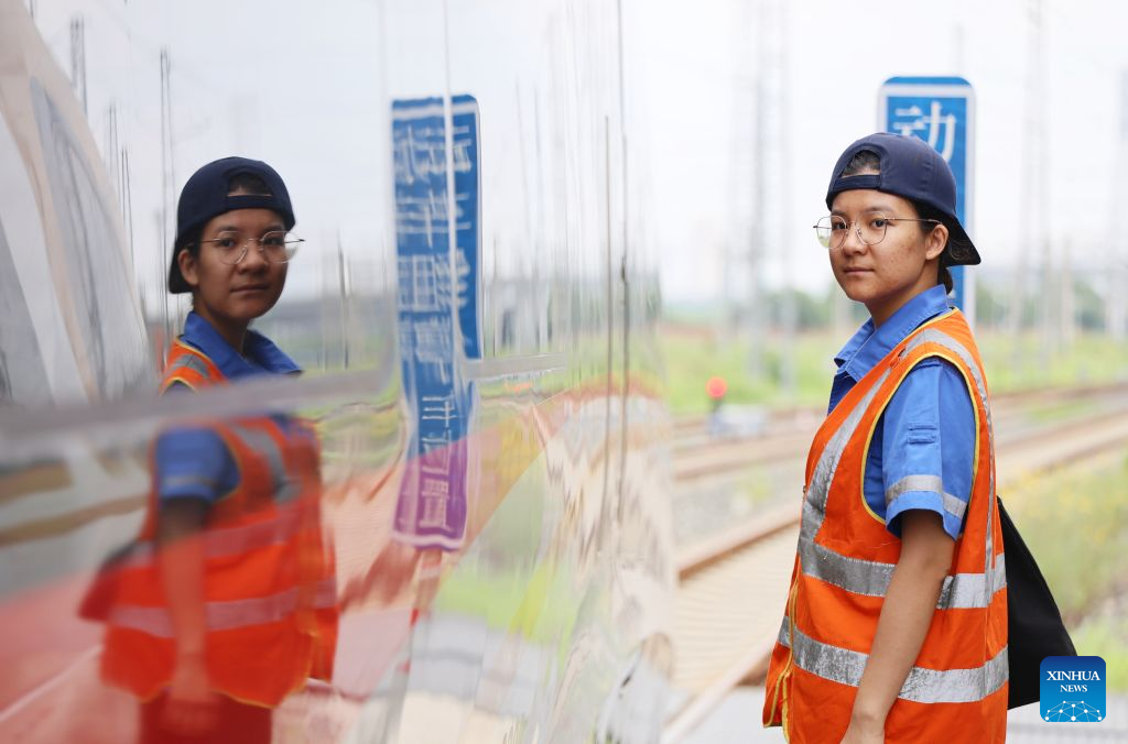 Li Weijia poses for a photo at an electric multiple unit (EMU) depot in Tianjin, north China, July 31, 2026. (Xinhua/Li Ran)