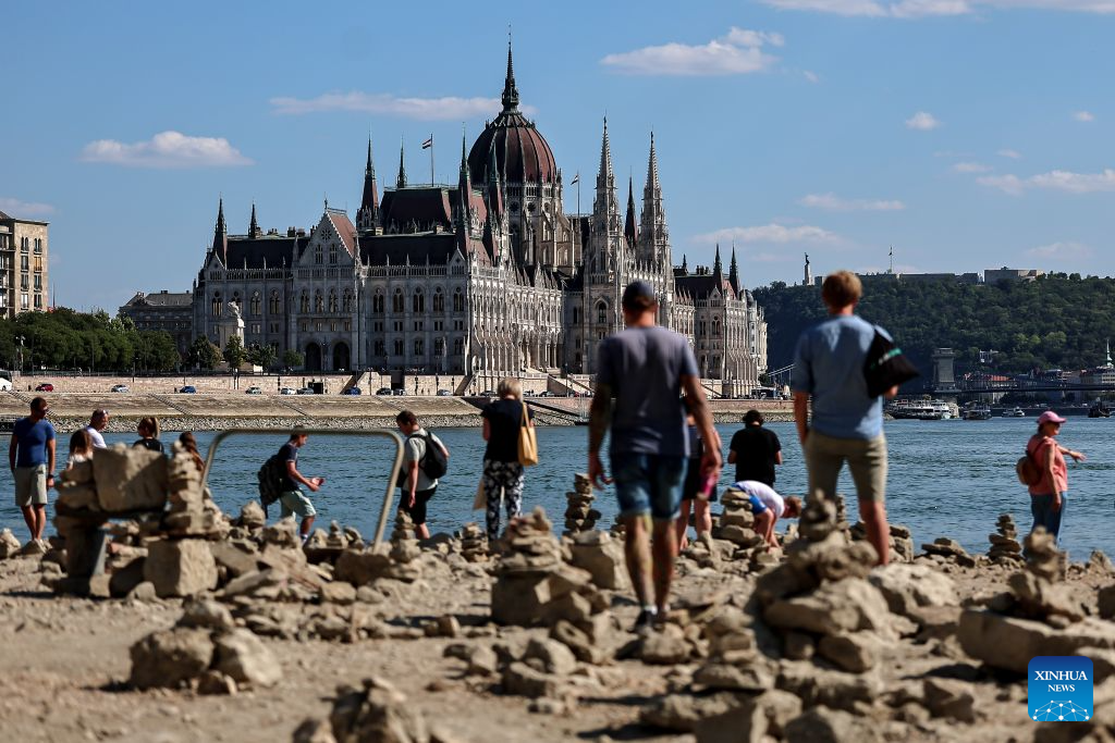 People explore the exposed riverbed of the Danube River in Budapest, Hungary, July 28, 2026. The water level of the Danube River in Budapest fell to a record low of 31 centimeters on Tuesday, according to Hungary's General Directorate of Water Management. The reading surpassed the previous record low of 33 centimeters which was measured on October 25, 2018, as prolonged drought and a lack of rainfall continue to affect much of the region. (Photo by David Balogh/Xinhua)