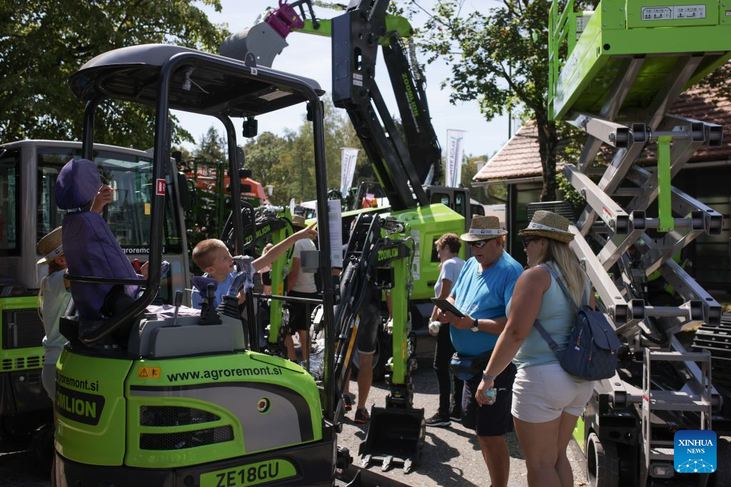 People observe agricultural machinery on display during the 64th International Fair of Agriculture and Food (AGRA) in Gornja Radgona, northeast Slovenia, Aug. 24, 2026. (Photo by Zeljko Stevanic/Xinhua)