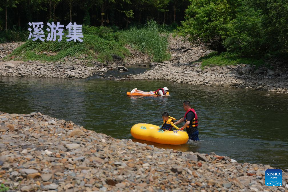 Visitors enjoy rafting in a stream in Anji County, east China's Zhejiang Province, Aug. 6, 2026. During the summer vacation, Anji County leverages its cool weather and beautiful scenery, attracting numerous tourists to escape the summer heat. (Xinhua/Huang Zongzhi)