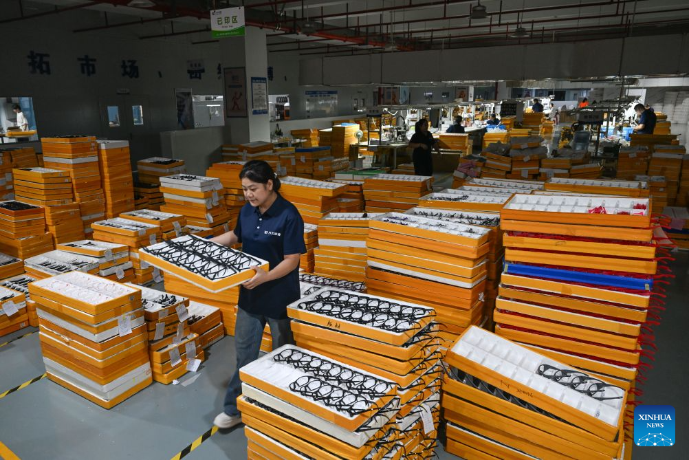A staff member carries eyeglasses to the warehouse at a workshop in Fengjie County, southwest China's Chongqing Municipality, Sept. 15, 2026. In recent years, Fengjie County has vigorously developed its eyewear industry, which provided over 3,500 new jobs, with products exported to more than 30 countries and regions. (Xinhua/Chen Cheng)