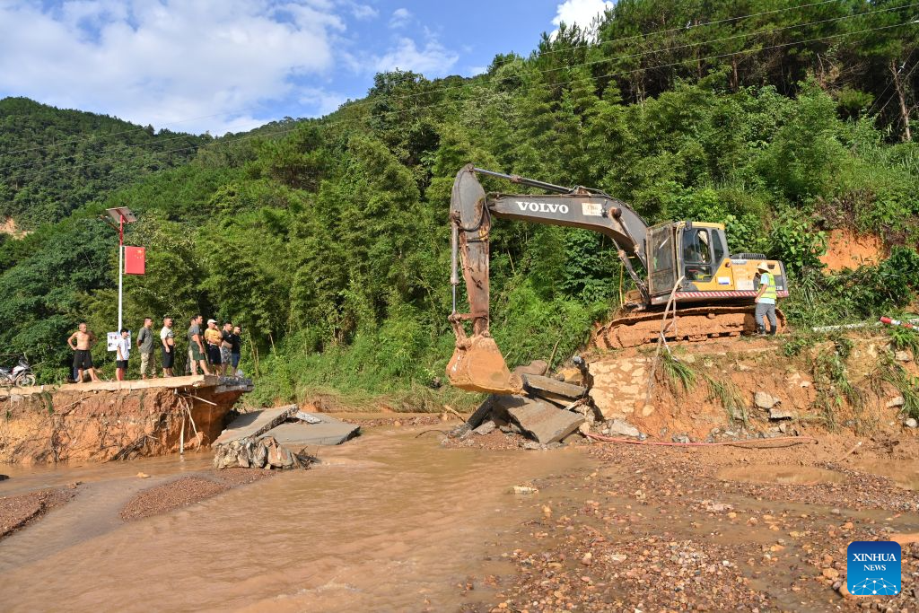 Workers repair a road section damaged by flood in Zhilang Township of Ningming County, Chongzuo City, south China's Guangxi Zhuang Autonomous Region, Aug. 25, 2026. Continuous heavy rainfall caused by Typhoon Narra, the 19th typhoon of the year, has swept across Ningming County. Local authorities have taken every efforts to clear, repair and reinforce the damaged roads and bridges. (Xinhua/Lu Boan)