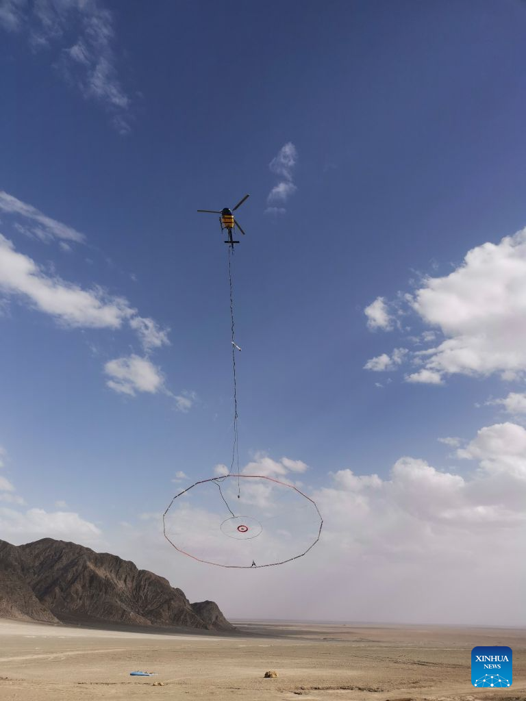 This photo taken on June 27, 2024 shows a helicopter-borne transient electromagnetic system designed by a research team at Jilin University in operation in Mangya, northwest China's Qinghai Province.(Xinhua)