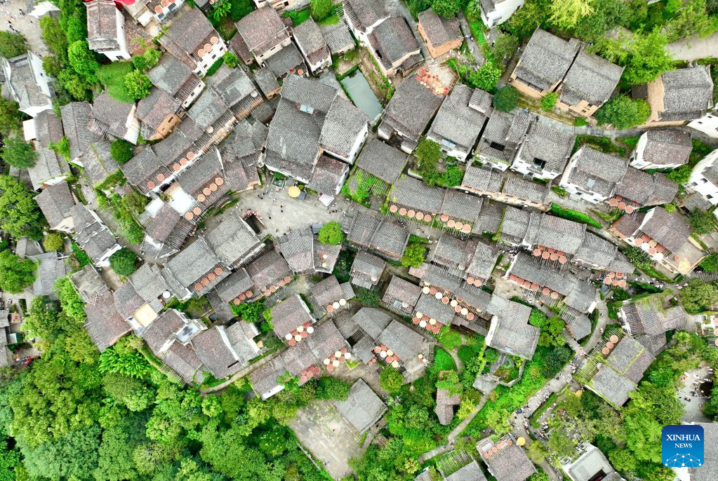 An aerial drone photo taken on Aug. 25, 2026 shows a view of Huangling Village in Wuyuan County, east China's Jiangxi Province. As early autumn sets in, villagers in Huangling spread harvested crops on bamboo trays to dry. Colorful drying trays form a striking contrast against Hui-style houses with white walls and black tiles, drawing crowds of tourists. (Xinhua/Hu Chenhuan)
