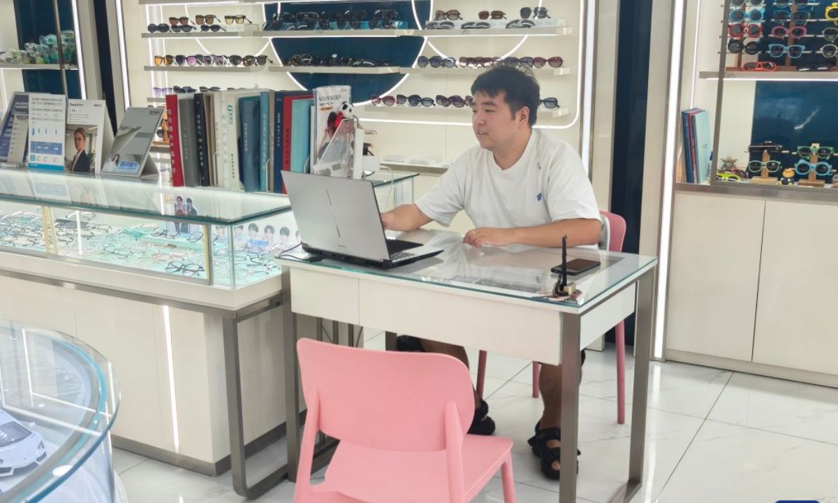 Chen Aijun works in an optical shop in Chengdu, southwest China's Sichuan Province, Aug. 14, 2026. (Xinhua/Lu Youyi)