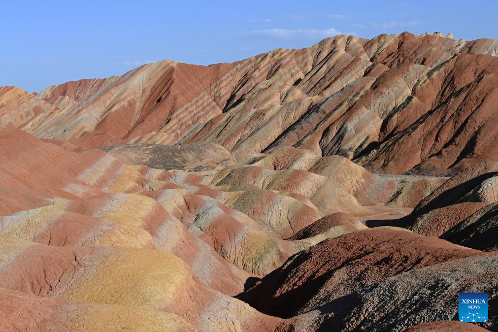 This photo taken on Aug. 4, 2026 shows a view of the Danxia landforms featuring striking red sandstone formations at the Zhangye Danxia Scenic Area in Zhangye, northwest China's Gansu Province. The scenic area in Gansu has entered its peak tourism season since August, with the average daily number of visitors surpassing 25,000. (Xinhua/Fan Peishen)