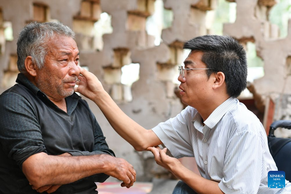 Li Chuangye (R) checks eyes of a senior in Bexkant Town, Shache County of northwest China's Xinjiang Uygur Autonomous Region, July 26, 2026. (Xinhua/Hu Huhu)