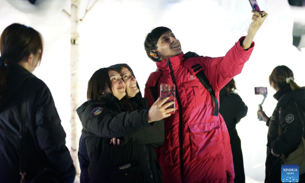 Foreign tourists take a selfie inside an ice-and-snow pavilion at Harbin Ice-Snow World park in Harbin, northeast China's Heilongjiang Province, on July 21, 2026.  (Xinhua/Na Yuqi)