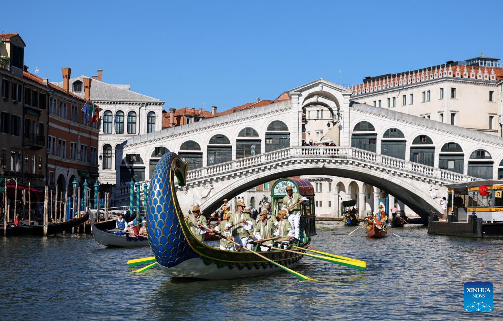 People sail past the Rialto Bridge in the Regata Storica boat race in Venice, Italy, Sept. 6, 2026. The Regata Storica is a historic annual boat parade and rowing race on the Grand Canal in Venice. (Xinhua/Wang Kaiyan)