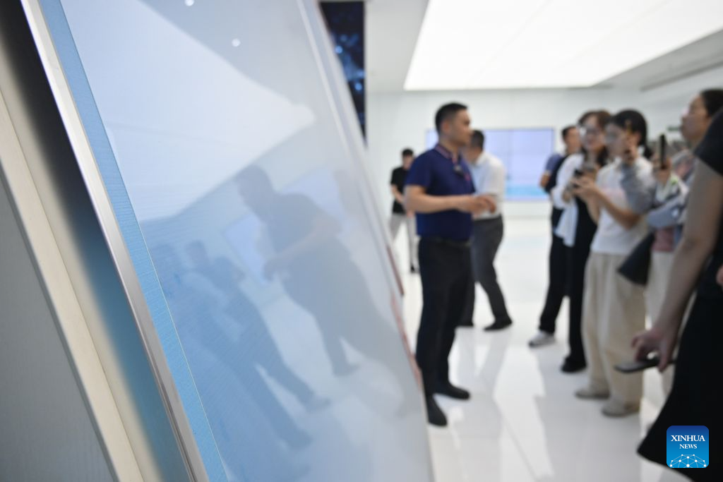 A staff member introduces a new glass product at a technology company in Bengbu, east China's Anhui Province, Aug. 8, 2026. Rooted in its glass industry, Bengbu has in recent years made breakthroughs in core technologies, successfully developed new glass products such as ultra-thin display glass and hollow glass microspheres, and established a complete industrial chain from quartz sand to end-user applications. (Photo by Lin Qiujin/Xinhua)