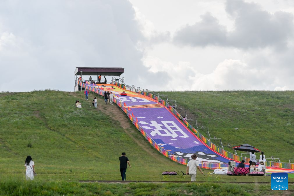 Tourists play by Baiyin Chagan Lake, or Milky Lake, in Xilin Gol League, north China's Inner Mongolia Autonomous Region, Aug. 4, 2026. The lake is dubbed Milky Lake as tiny mineral particles float in the water, turning it creamy-white like milk. (Xinhua/Lian Zhen)