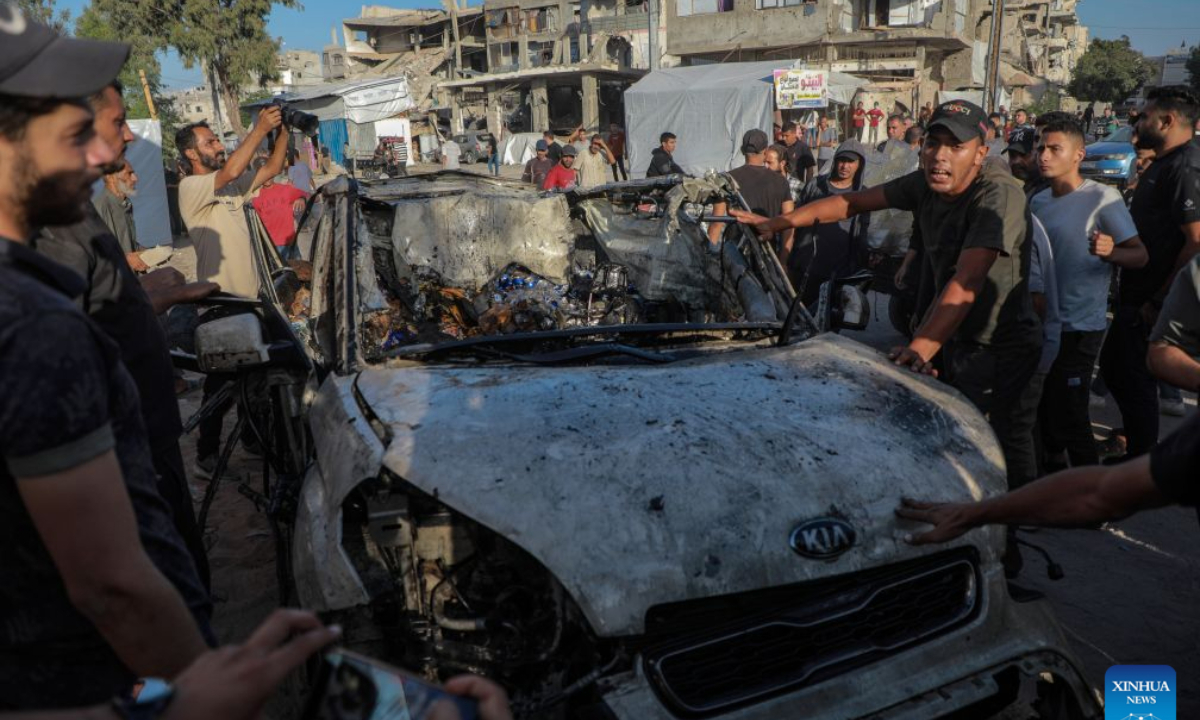 Palestinians gather around a burned vehicle following an Israeli drone strike targeting a civilian vehicle, in the Tel al-Hawa area west of Gaza City, Oct. 8, 2026. Two Palestinians were killed and several others injured Thursday in an Israeli strike targeting a vehicle west of Gaza City, according to medical and local sources. (Photo by Rizek Abdeljawad/Xinhua)