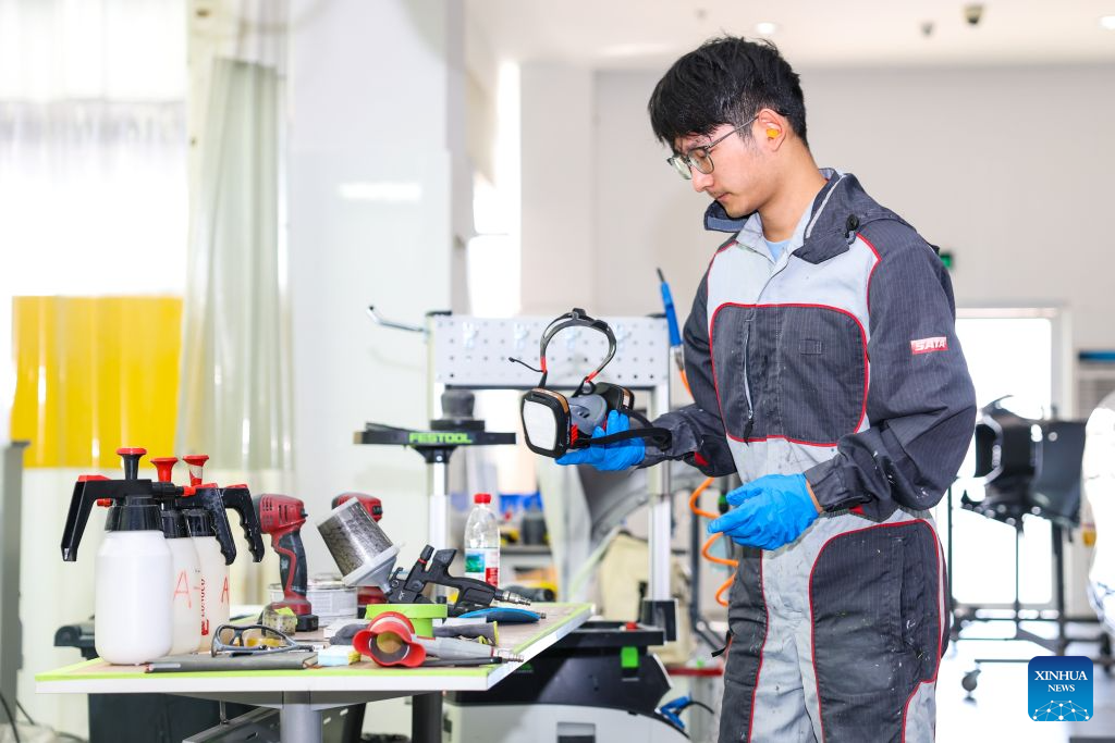 Duan Libo trains for the car painting skill competition of the 48th WorldSkills Competition at a training facility of Hangzhou Technician Institute in Hangzhou, east China's Zhejiang Province, Sept. 7, 2026. Duan Libo, born in southwest China's Yunnan Province in 2004, is a student majoring in automotive sheet metal and painting at Hangzhou Technician Institute. He has been preparing for the car painting skill competition at the 48th WorldSkills Competition in Shanghai.
At the training facility, Duan, dressed in full protective gear, conducted practical training under the guidance of coaches, translators, and assistants. Coach Jiang Yingcheng, who won the championship in car painting at the 44th WorldSkills Competition, said this year's competition places higher demands on participants' skills, physical fitness, and mental resilience.
The car painting skill competition involves restoring a damaged vehicle to its original finish by precisely matching colors, shades, and textures, while meeting safe and environmental requirements.
Duan's training schedule runs from 8 a.m. to 10 p.m., with various sessions throughout the day. In preparation for this international event, Duan has posted English words and phrases related to the competition outside the spray-painting booth.
During the training, Duan listened attentively to his coach's feedback and the translator's explanations of technical terms in English, while remaining focused on his work. Sweating yet composed, he meticulously refined his work, striving to earn a place on the WorldSkills podium. (Xinhua/Jiang Han)
