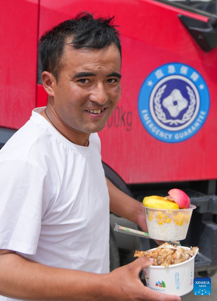 A driver who takes part in rescue operations gets his lunch from a food truck in mudslide-affected Gyirong Town, southwest China's Xizang Autonomous Region, Aug. 31, 2026.
A food truck has been deployed in mudslide-affected Gyirong Town of Gyirong County recently, providing hot meals to disaster relief volunteers. The truck came from the neighboring Tingri County. After being hit by an earthquake in 2025, Tingri County purchased the truck with funds from east China's Shanghai under an assistance program for Xizang. After Gyirong Town was hit by the mudslide, Tingri County soon dispatched the truck to share mobile food services for disaster relief. (Xinhua/Jigme Dorje)