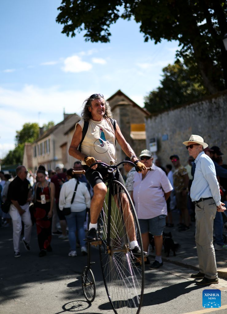 A vintage cyclist is seen at the Harvest Festival in Provins, France, Aug. 23, 2026. The medieval town of Provins celebrated its Harvest Festival on Sunday, featuring float parades, traditional threshing demonstrations, vintage tractors and folk dances. (Xinhua/Wu Huiwo)