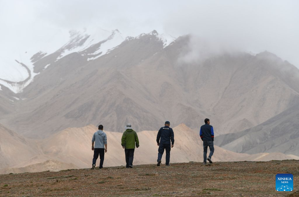 Rangers search for suspicious vehicle tracks indicating illegal entry in the Altun Mountain National Nature Reserve in northwest China's Xinjiang Uygur Autonomous Region, on Aug. 9, 2026. Averaging 4,500 meters in elevation, the Altun Mountain National Nature Reserve, a 45,000-square-kilometer haven situated in the southeastern corner of Xinjiang, is subject to harsh environmental conditions.
In early August, a patrol team comprising nature reserve staff, local township officials and police officers ventured into this remote plateau wilderness for a monthly routine patrol.
Bumping along a dry river valley winding through the mountains, the team members checked for suspicious signs, observed wildlife, and maintained management station facilities. They conducted routine inspections within the reserve supported by advanced technological equipment, including high-altitude surveillance cameras, infrared cameras and drones. Their main mission was to curb illegal activities to ensure protection of one of China's most remote and ecologically vital sanctuaries.
At nearly 4,800 meters above sea level, almost every member of the team suffered from altitude sickness like headaches and insomnia, but their firm conviction to protect this reserve gave them strength to overcome challenges and carry on with their work.
Established in 1983, the reserve is managed by a team of about 70 people. Over the past 40 years, generation after generation of patrollers have devoted themselves to protecting this land with stark contrasts and rich biodiversity. (Xinhua/Hu Huhu)