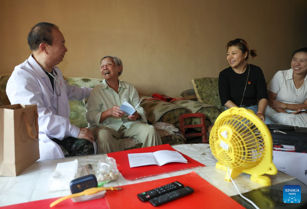 Zhuang Shihua (1st L) visits a patient (2nd L) for free clinic service in Urumqi, northwest China's Xinjiang Uygur Autonomous Region, July 27, 2026.
Zhuang Shihua, a veteran hepatobiliary surgeon and former president of the hospital affiliated to the Xinjiang Armed Police Corps, has been in the country's far west for over five decades.
His team has successfully completed more than 140,000 minimally invasive hepatobiliary surgeries, and made seven breakthroughs that filled the domestic gap in the field. Apart from clinical practice, Zhuang has cultivated a large number of key personnel, and supported grassroots medical workers who have stood firm on the front lines of public health.
Zhuang's medical expertise brought him many opportunities to make a fortune, but he turned down the offers and stayed in Xinjiang.
Zhuang often visited patients in the pastoral areas of Tianshan Mountains. He also provided financial assistance to over 70 underprivileged students and helped more than 690 households with patients out of poverty. (Xinhua/Wang Fei)
