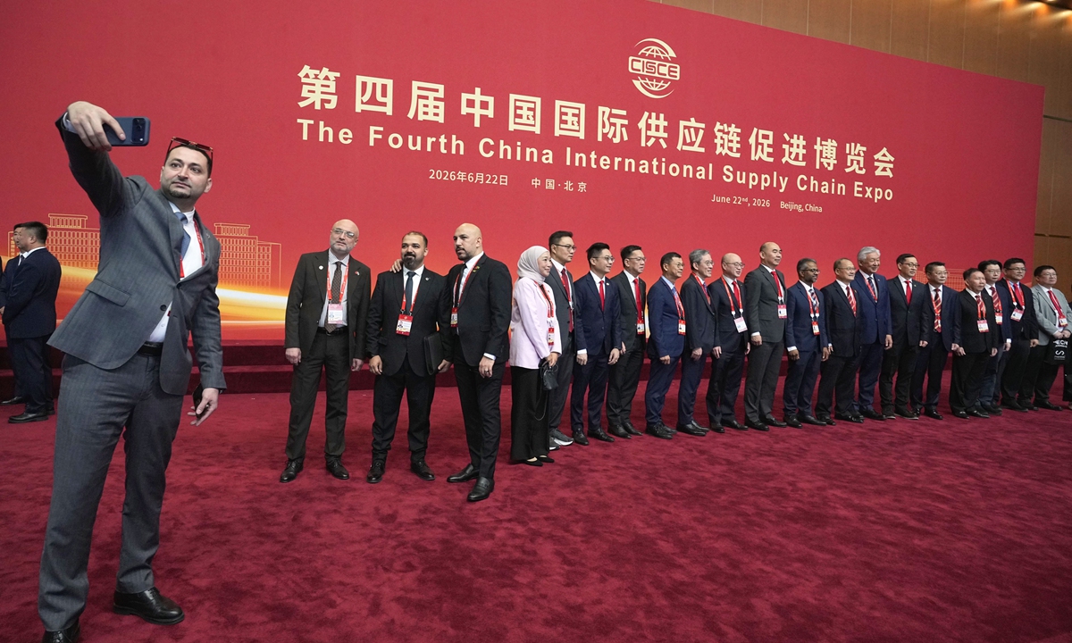 Attendees take selfies at the opening ceremony of the 4th China International Supply Chain Expo in Beijing on June 22, 2026. Photo: VCG