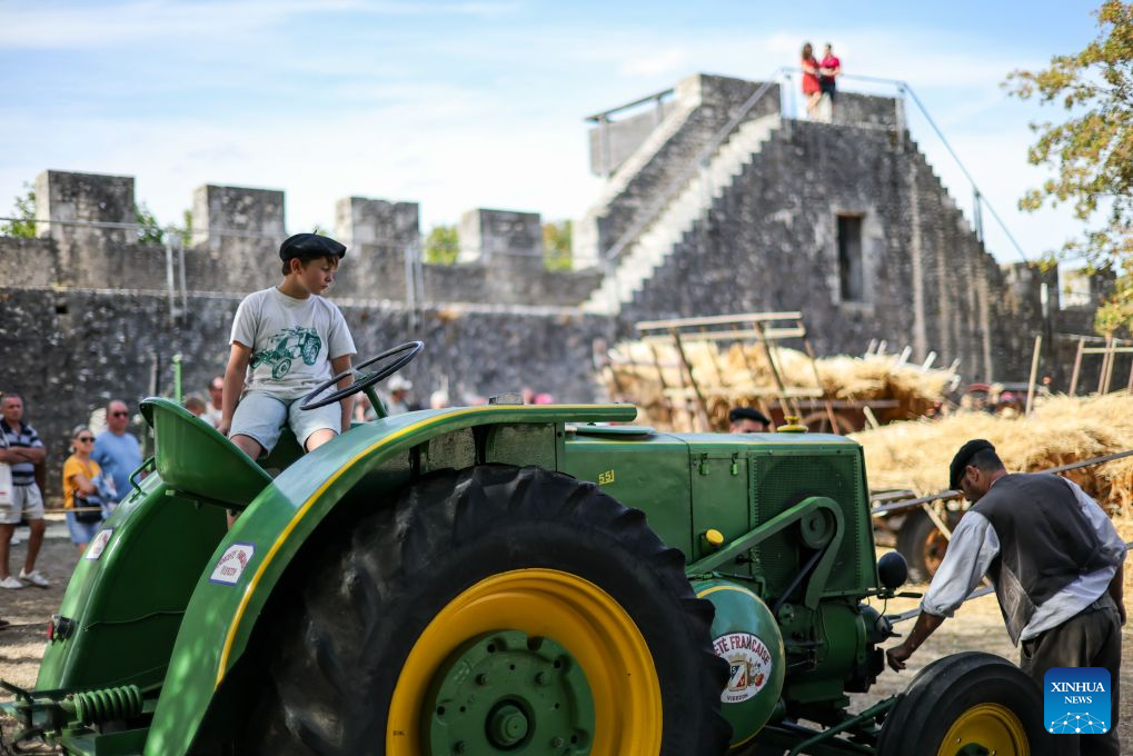 Performers demonstrate traditional threshing during the Harvest Festival in Provins, France, Aug. 23, 2026. The medieval town of Provins celebrated its Harvest Festival on Sunday, featuring float parades, traditional threshing demonstrations, vintage tractors and folk dances. (Xinhua/Wu Huiwo)