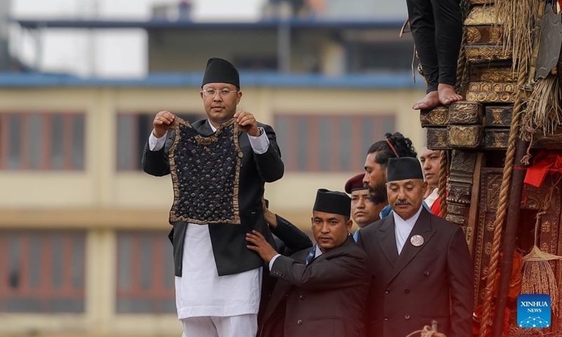An official displays the traditional ornamental vest known as the Bhoto to the public during the Bhoto Jatra festival, the concluding event of the Rato Machhindranath chariot festival, in Lalitpur, Nepal, June 20, 2026. (Photo by Sulav Shrestha/Xinhua)

