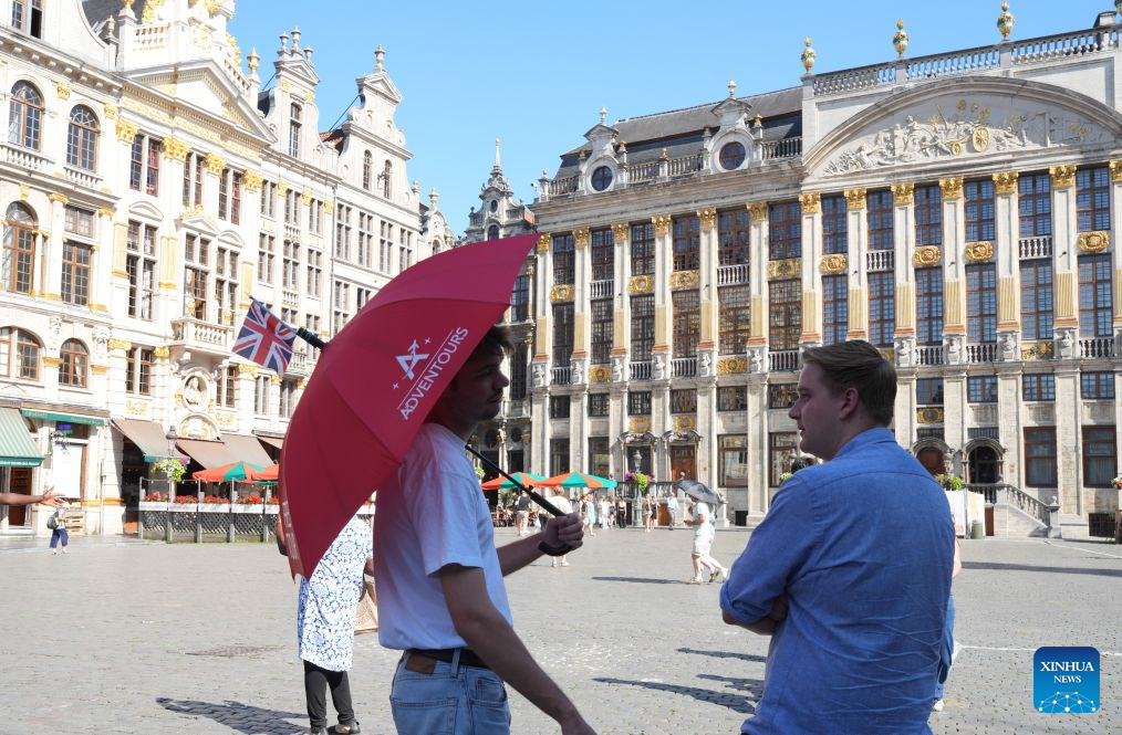 A man stands under an umbrella during a heatwave at the Grand Place in Brussels, Belgium, on July 29, 2026. (Xinhua/Weng Xinyang)