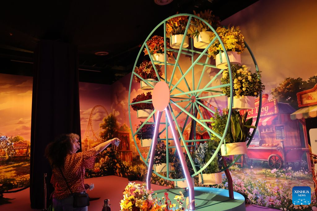 Visitors attend a flower exhibition in Tel Aviv, Israel, Aug. 18, 2026. Around 50 Israeli floral designers spent weeks using millions of flowers to create a vibrant floral wonderland. (Photo by Gil Cohen Magen/Xinhua)