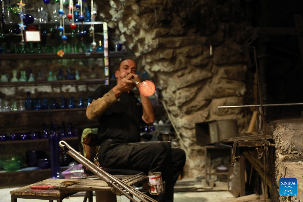 Palestinian Yaqub Al-Natsheh works at his glass factory in the West Bank city of Hebron, on Aug. 23, 2026. The city of Hebron is well known for its skillful glass blowers and designers. Glass factories making hand-blown glass products have a long history in the city. (Photo by Mamoun Wazwaz/Xinhua)