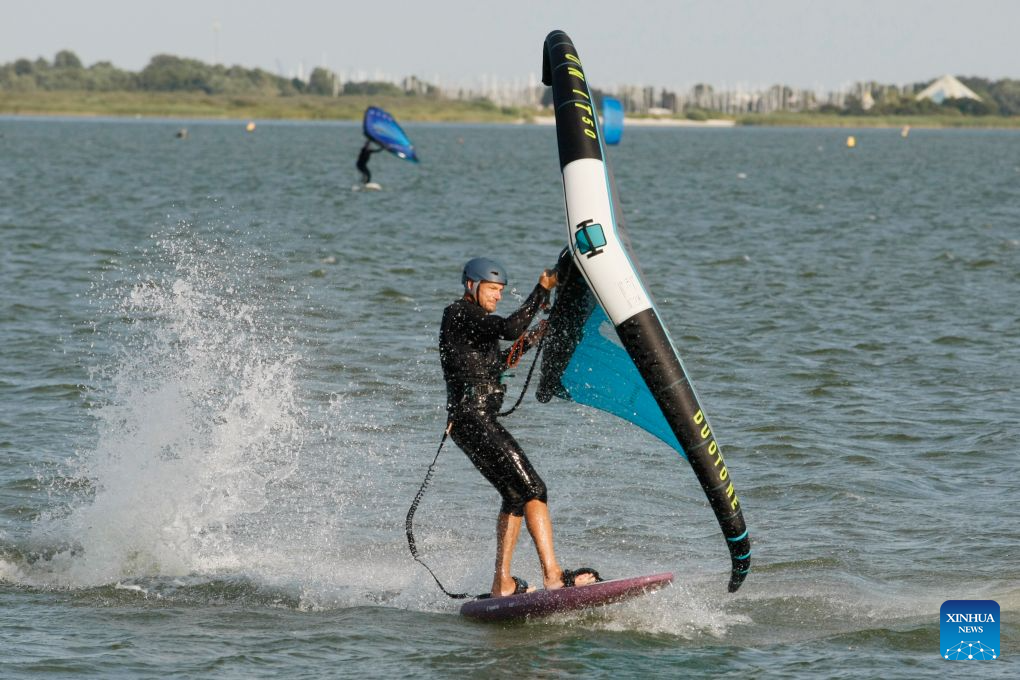 A surfing enthusiast surfs on the Ijsselmeer lake near Kornwerderzand in Friesland Province, the Netherlands, Aug. 2, 2026. (Xinhua/Shao Haijun)
