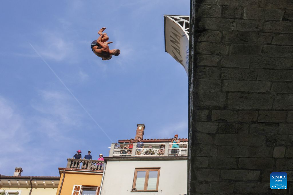 A participant jumps into the River Soca from a 17-meter-high bridge during a traditional jumping event in Kanal ob Soci, Slovenia, on Aug. 16, 2026. (Photo by Zeljko Stevanic/Xinhua)