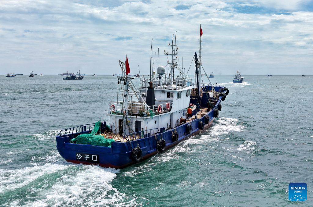 A drone photo taken on Sept. 1, 2026 shows a fishing boat sailing out of a fishing port in Qingdao, east China's Shandong Province. The new fishing season in the Yellow Sea and Bohai Sea kicked off on Tuesday after a four-month summer fishing moratorium. (Xinhua/Li Ziheng)