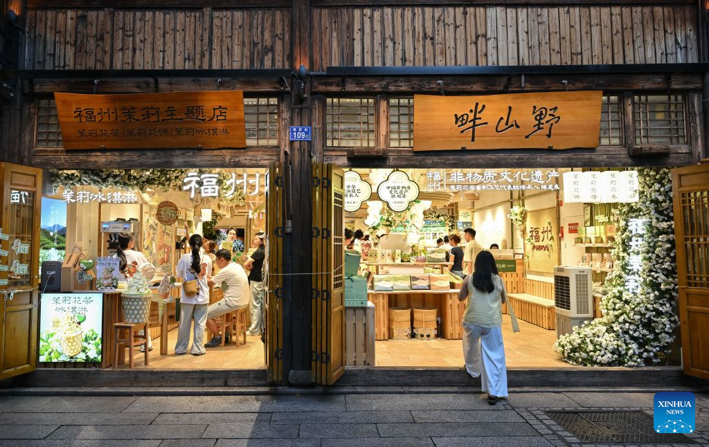 Tourists shop at a jasmine-themed store at a traditional block in Fuzhou, southeast China's Fujian Province, on July 22, 2026. Fuzhou's traditional jasmine tea scenting craftsmanship, a national intangible cultural heritage, is driving the city's cultural tourism development. Leveraging its century-old jasmine tea industrial heritage, the city has restored historic tea plantations and scenting workshops while developing tea-themed industrial, educational and cultural attractions. In recent years, the renowned jasmine tea heritage has been transformed into a vibrant driver of the city's cultural tourism growth. (Xinhua/Han Xu)