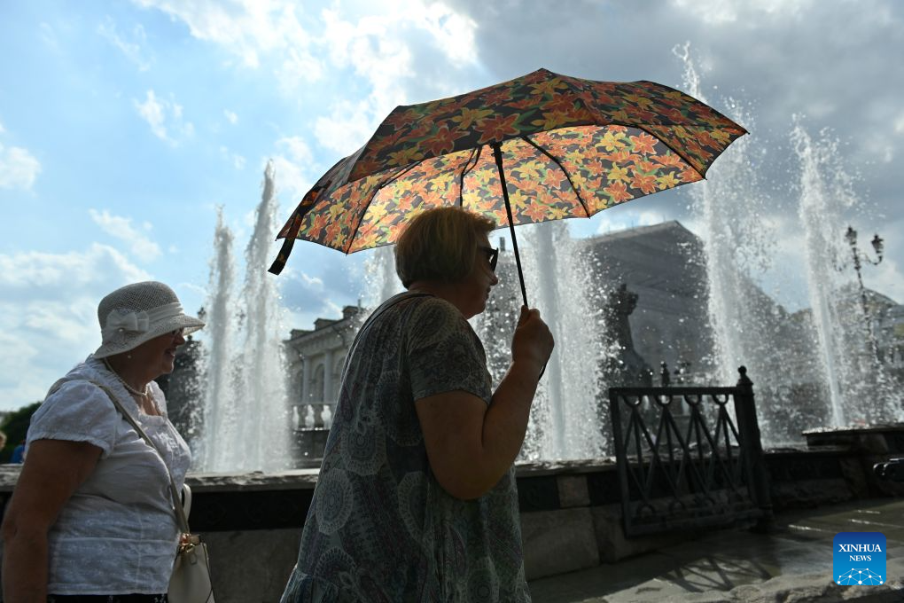 Women walk past a fountain near the Red Square under the blazing sun in Moscow, Russia, Aug. 6, 2026. (Photo by Alexander Zemlianichenko Jr/Xinhua)