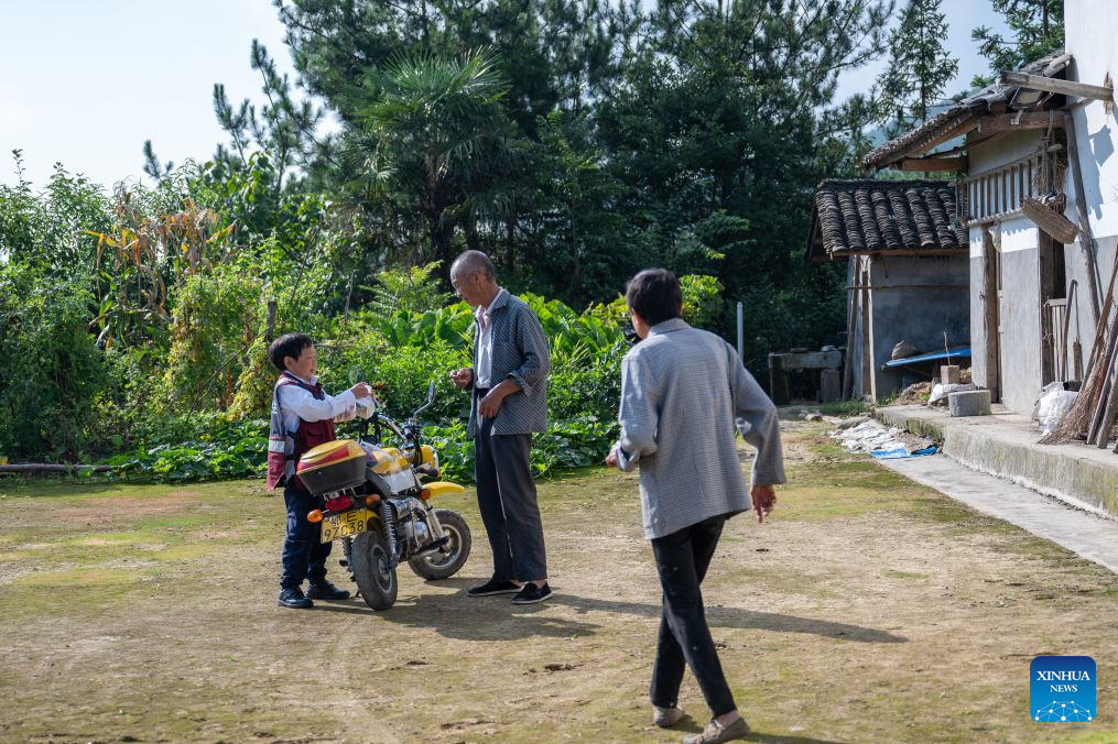 Wang Ju (L) delivers medicine to a household in Lianghe Village, Lianghekou Town, Zigui County of Yichang, central China's Hubei Province, Aug. 16, 2026. (Xinhua/Du Zixuan)