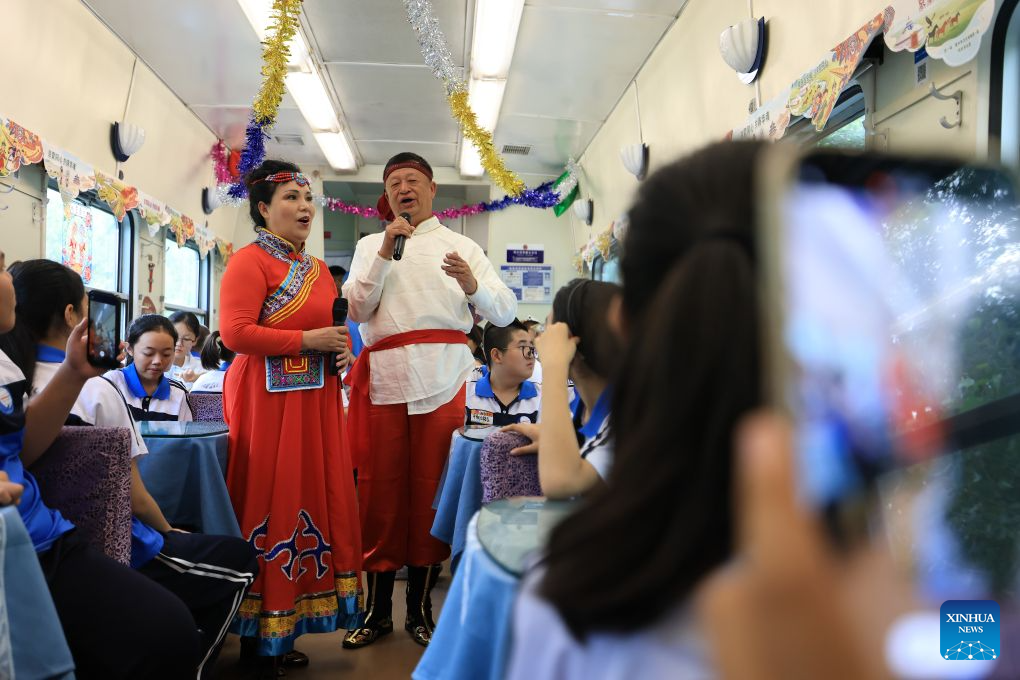 Performers sing Mongolian songs for students on a special train for study tour from northeast China's Heilongjiang Province to the capital city of Beijing on Aug. 9, 2026. The Y404 special train for a study tour carrying 598 teachers and students on Sunday departed from the Qiqihar railway station in northeast China's Heilongjiang Province to Beijing, capital of China.

The Heilongjiang-to-Beijing train is specially organized by China Railway Harbin Bureau Group Co., Ltd. this year for students on study tours, serving as a mobile classroom with singing and dancing activities held on it, where students on their way have the chance to interact and experience the charm of cultures. (Photo by Xu Shuai/Xinhua)