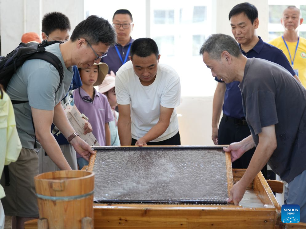 Tourists learn to make Xuan paper at a Xuan paper cultural town in Jingxian County, east China's Anhui Province, on July 31, 2026. (Xinhua)