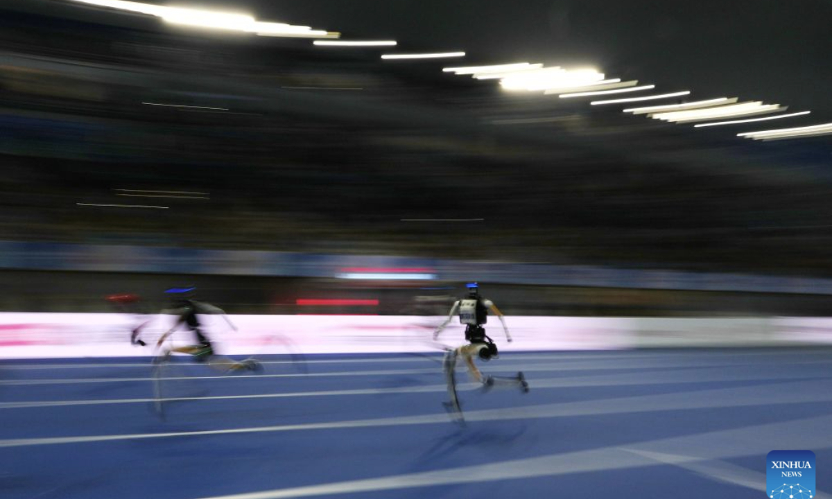 Robots compete during the 100m - Large Group of the 2nd World Humanoid Robot Games in Beijing, capital of China, Aug. 25, 2026. (Xinhua/Ju Huanzong)
