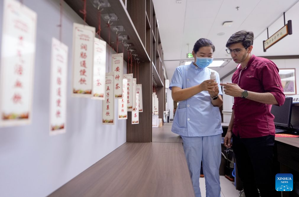Mohammad Abdi (R) learns about TCM herbal drinks from a doctor at Ningxia Chinese Medicine Research Center in Yinchuan, northwest China's Ningxia Hui Autonomous Region, on Aug. 15, 2026. Mohammad Abdi, a 26-year-old Iranian student, came to China in 2023 to study clinical medicine at Ningxia Medical University.
He was introduced to traditional Chinese medicine (TCM) at an early age. After seeing his uncle receive cupping therapy in Iran, he became curious about this traditional medical practice. Later, as a medical student in China, he had the opportunity to take professional TCM courses. On weekends, Abdi visits Ningxia Chinese Medicine Research Center to experience various TCM therapies.
I was a gym rat, so I initially thought TCM practices were too simple to be effective, he said. However, as he learned more about TCM, he was impressed by its depth and effectiveness. He recommended Baduanjin, a traditional Chinese breathing and stretching exercise, to his fellow international students, while he especially enjoys tuina massage combined with cupping therapy, which helps relieve the stress of his studies and clinical internship.
For Abdi, TCM is more than a way to treat diseases; it is also a health philosophy that can be integrated into daily life. He believes ordinary people can benefit from TCM-based wellness practices, while professional doctors can use TCM techniques to treat patients.
TCM is now expanding its global presence and joining the worldwide conversation on health and lifestyle. Inspired by growing interest in Chinese lifestyles overseas, Abdi hopes to continue exploring TCM and become a skilled doctor, helping more people in his hometown benefit from traditional Chinese medicine. (Xinhua/Yang Zhisen)